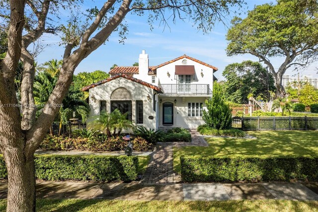 mediterranean / spanish-style house with a balcony and a lawn