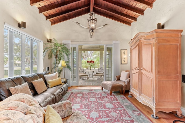 sunroom with a notable chandelier, french doors, wood ceiling, and lofted ceiling with beams