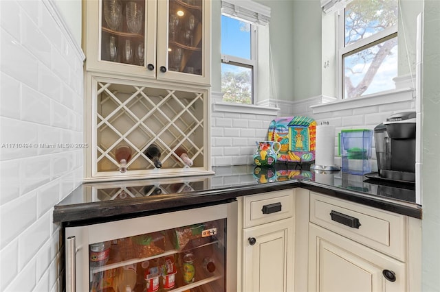 bar featuring beverage cooler, a bar, and tasteful backsplash