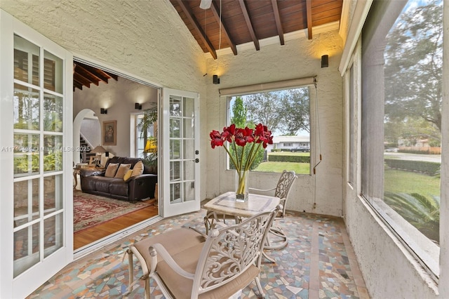 sunroom with arched walkways, wooden ceiling, and vaulted ceiling with beams