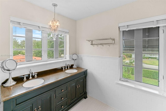 full bath featuring a wainscoted wall, tile walls, and a sink