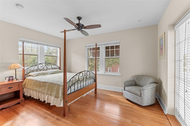 bedroom with ceiling fan, baseboards, and light wood-style flooring