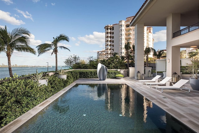 view of pool with a patio and a water view