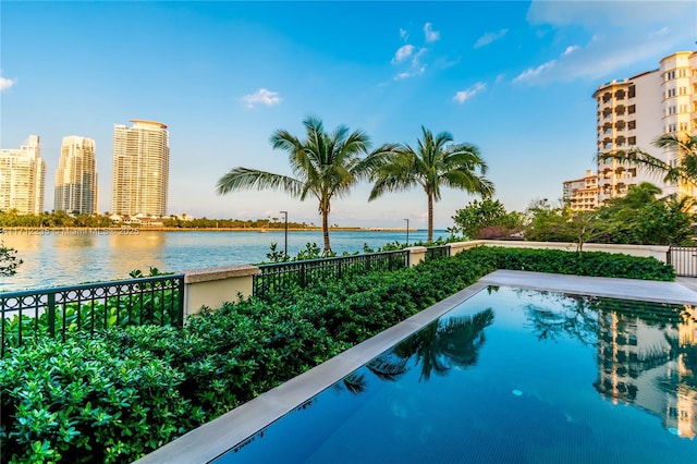 view of swimming pool featuring a city view and a water view