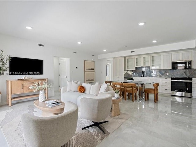 living area featuring marble finish floor, visible vents, and recessed lighting