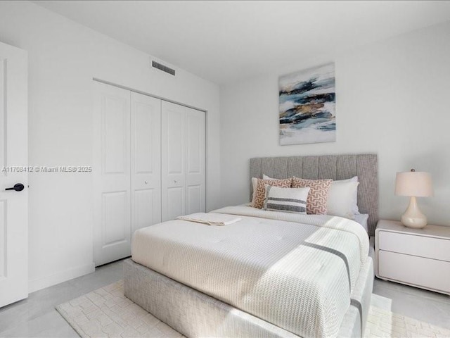 bedroom with visible vents, concrete flooring, and a closet