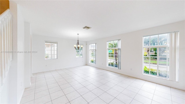 unfurnished room with light tile patterned floors and an inviting chandelier