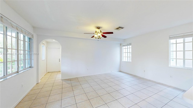 tiled empty room featuring ceiling fan