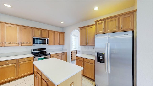 kitchen with light tile patterned floors, a center island, and stainless steel appliances