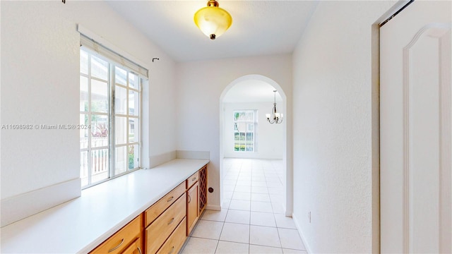 interior space with plenty of natural light, light tile patterned flooring, and a chandelier