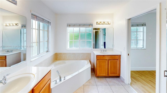 bathroom with a washtub, vanity, and tile patterned floors