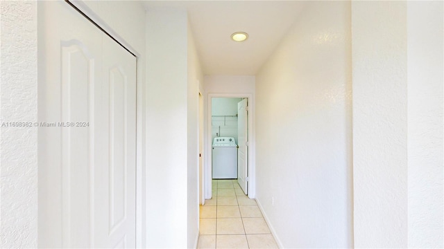 corridor with light tile patterned floors and washer / dryer