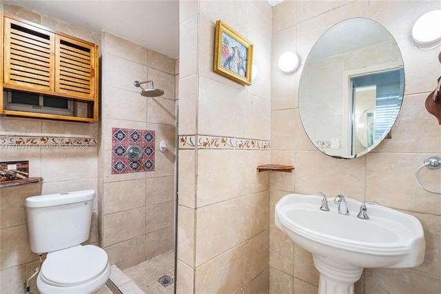 bathroom with tiled shower, toilet, and tile walls