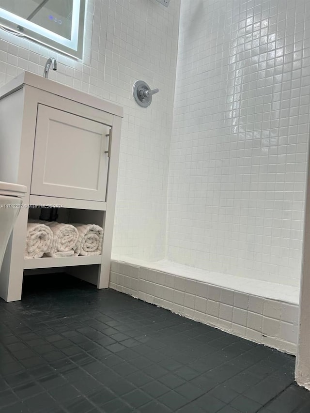 bathroom featuring tile patterned flooring and a tile shower