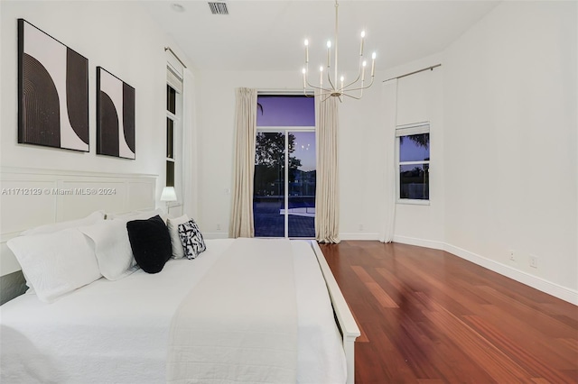 bedroom with hardwood / wood-style floors and a chandelier