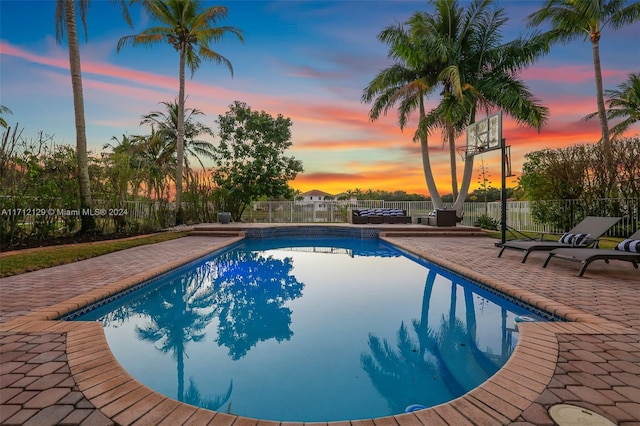 pool at dusk with a patio area