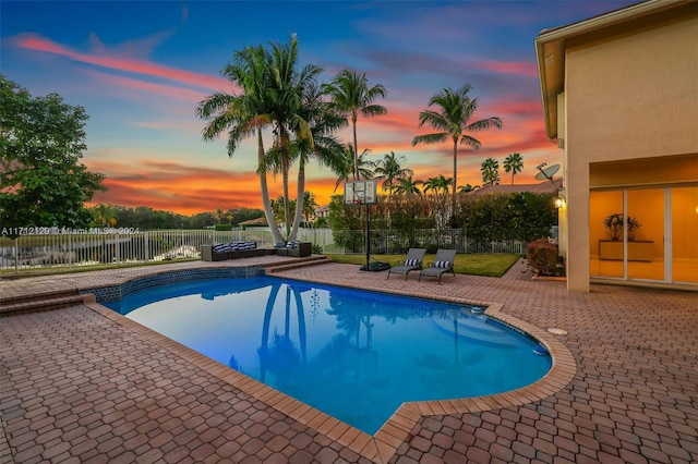 pool at dusk with a patio