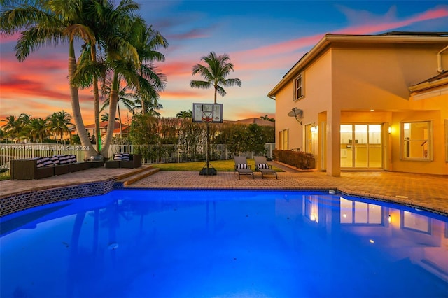 pool at dusk with a patio