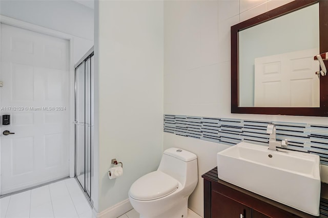 bathroom featuring decorative backsplash, vanity, toilet, and a shower with door