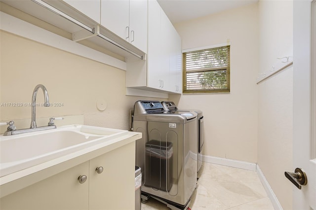 laundry area with washer and clothes dryer, cabinets, and sink