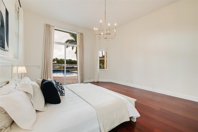 bedroom with access to outside, wood-type flooring, and a notable chandelier