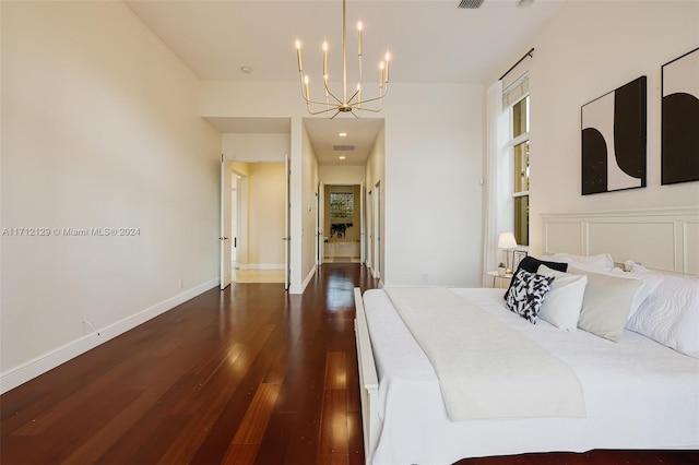 bedroom featuring dark wood-type flooring and an inviting chandelier