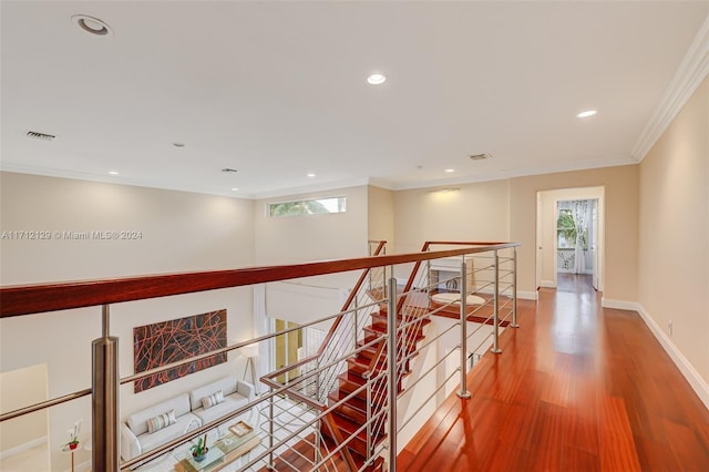 hallway with plenty of natural light, wood-type flooring, and ornamental molding