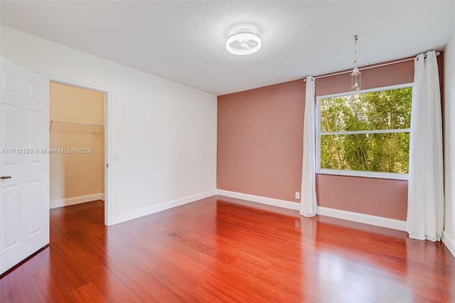 unfurnished room featuring wood-type flooring and a textured ceiling