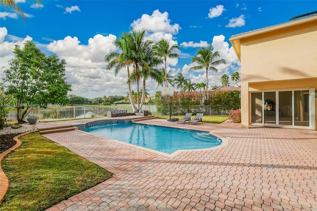 view of pool with a water view and a patio