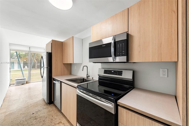 kitchen with light brown cabinets, sink, and appliances with stainless steel finishes