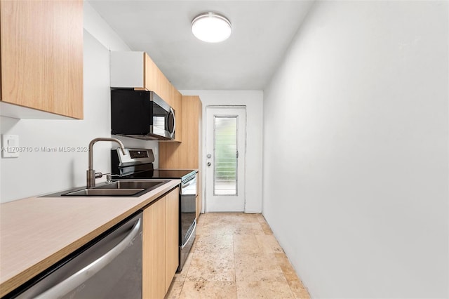 kitchen featuring light brown cabinetry, stainless steel appliances, and sink