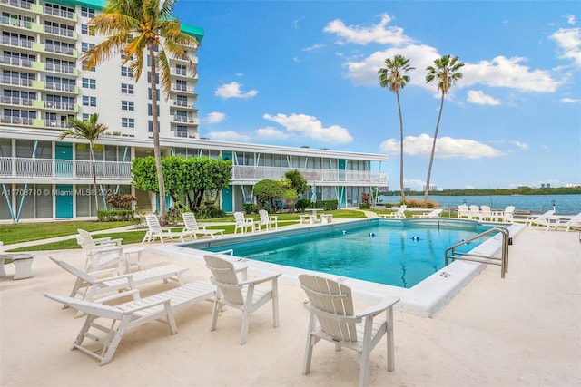 view of pool featuring a patio area and a water view