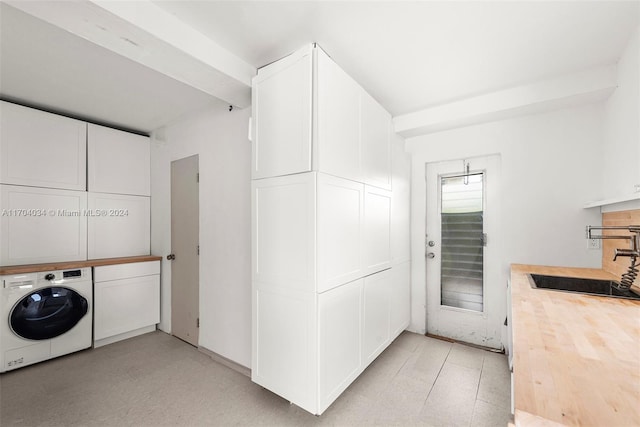 laundry area with cabinets, washer / dryer, and sink