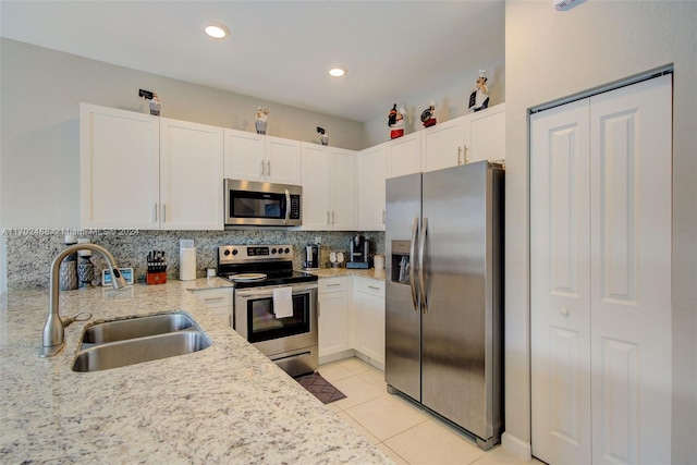 kitchen featuring light stone counters, sink, white cabinets, and stainless steel appliances