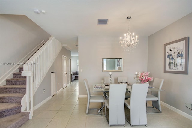 tiled dining room featuring a chandelier