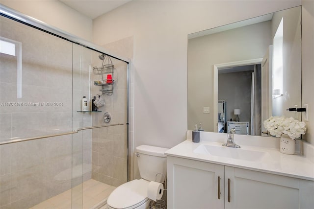 bathroom featuring vanity, an enclosed shower, and toilet