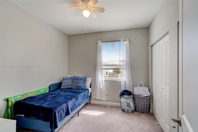 carpeted bedroom with ceiling fan and a closet