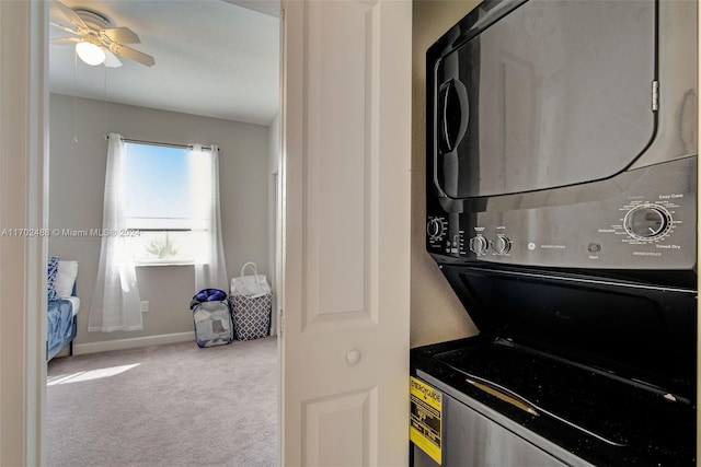 laundry area with ceiling fan, stacked washer / dryer, and light carpet