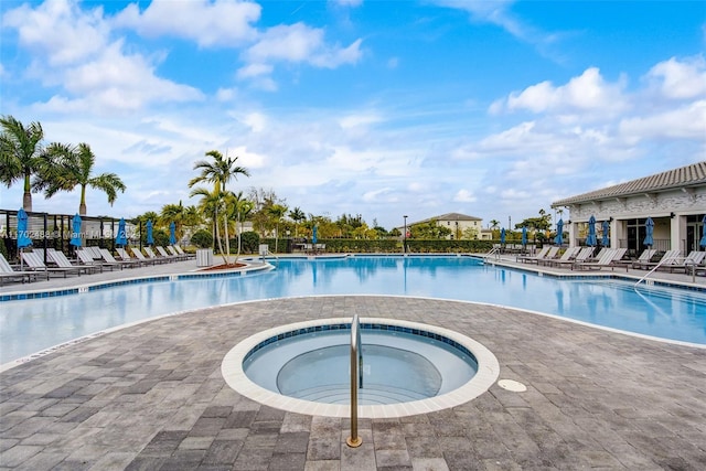 view of swimming pool featuring a patio area and a hot tub