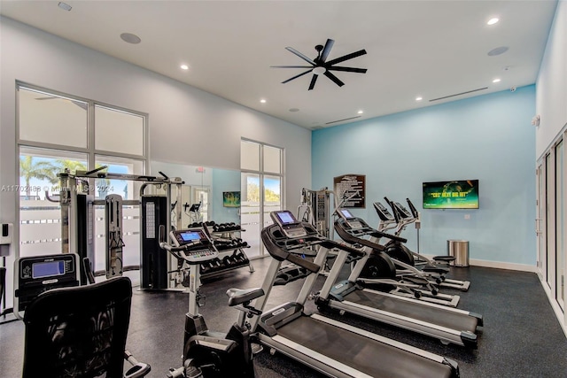 workout area featuring ceiling fan and a towering ceiling