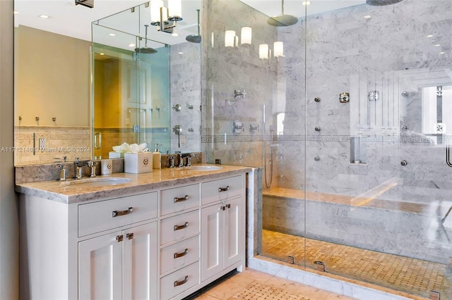 bathroom with an enclosed shower, vanity, tile patterned floors, and tile walls