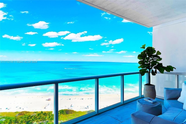 balcony featuring baseboard heating, a water view, and a beach view