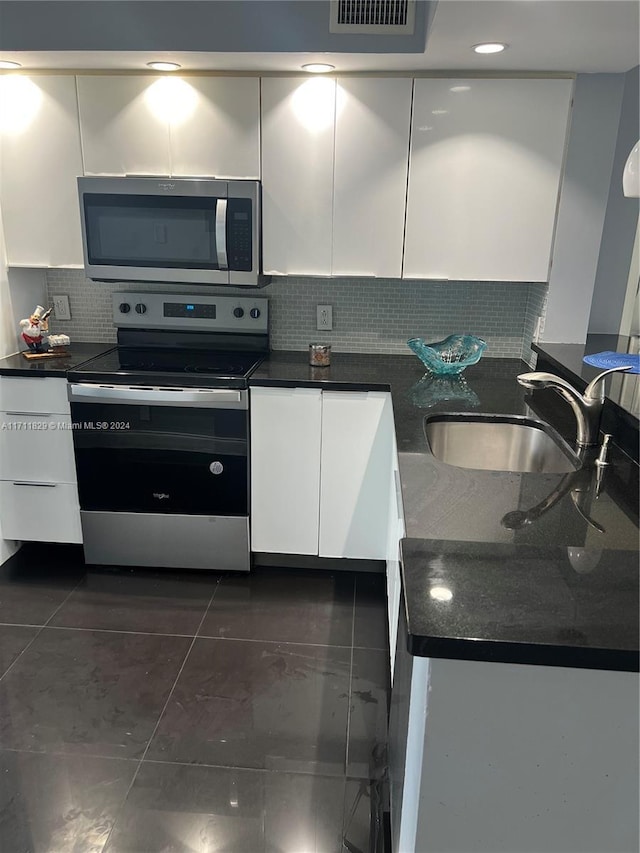 kitchen featuring backsplash, white cabinetry, sink, and stainless steel appliances