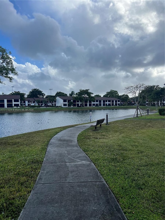 surrounding community with a lawn and a water view