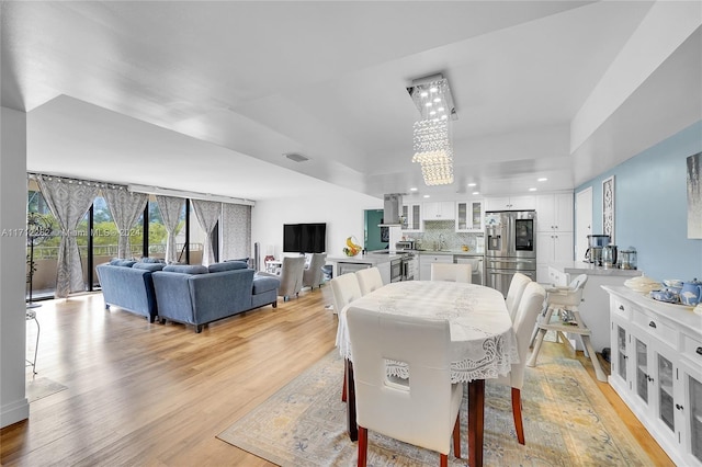 dining area featuring light wood-type flooring and a chandelier