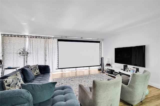 cinema featuring light hardwood / wood-style floors and an inviting chandelier