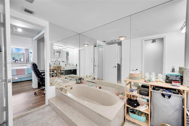 bathroom featuring vanity, a bath, and hardwood / wood-style flooring