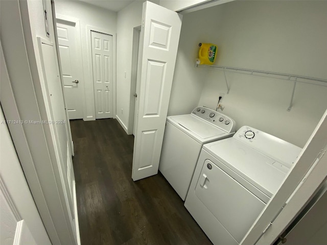 clothes washing area featuring washer and clothes dryer and dark hardwood / wood-style floors