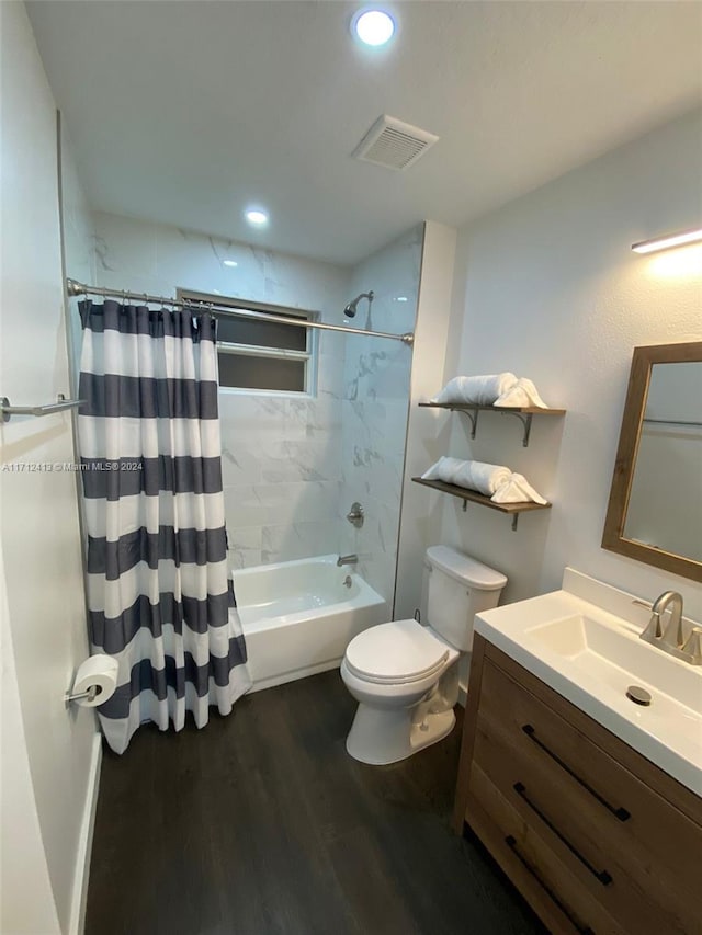 full bathroom featuring hardwood / wood-style floors, vanity, shower / tub combo, and toilet