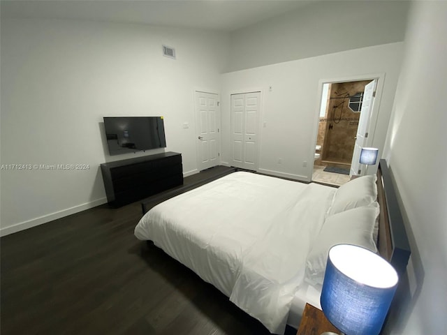 bedroom featuring connected bathroom, a closet, high vaulted ceiling, and dark hardwood / wood-style floors